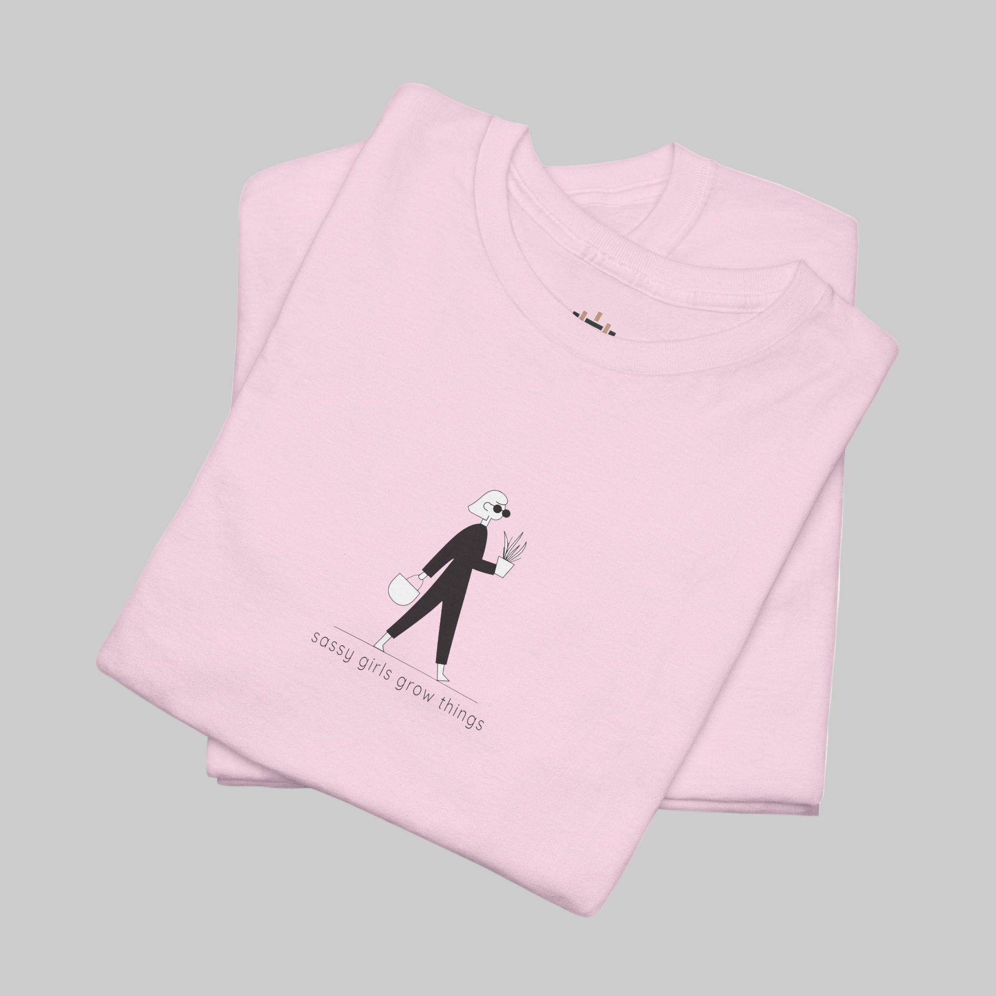 Folded pink t-shirt with a graphic design and text on a white background