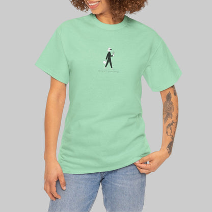 Person wearing a light green t-shirt with a small graphic on a white background