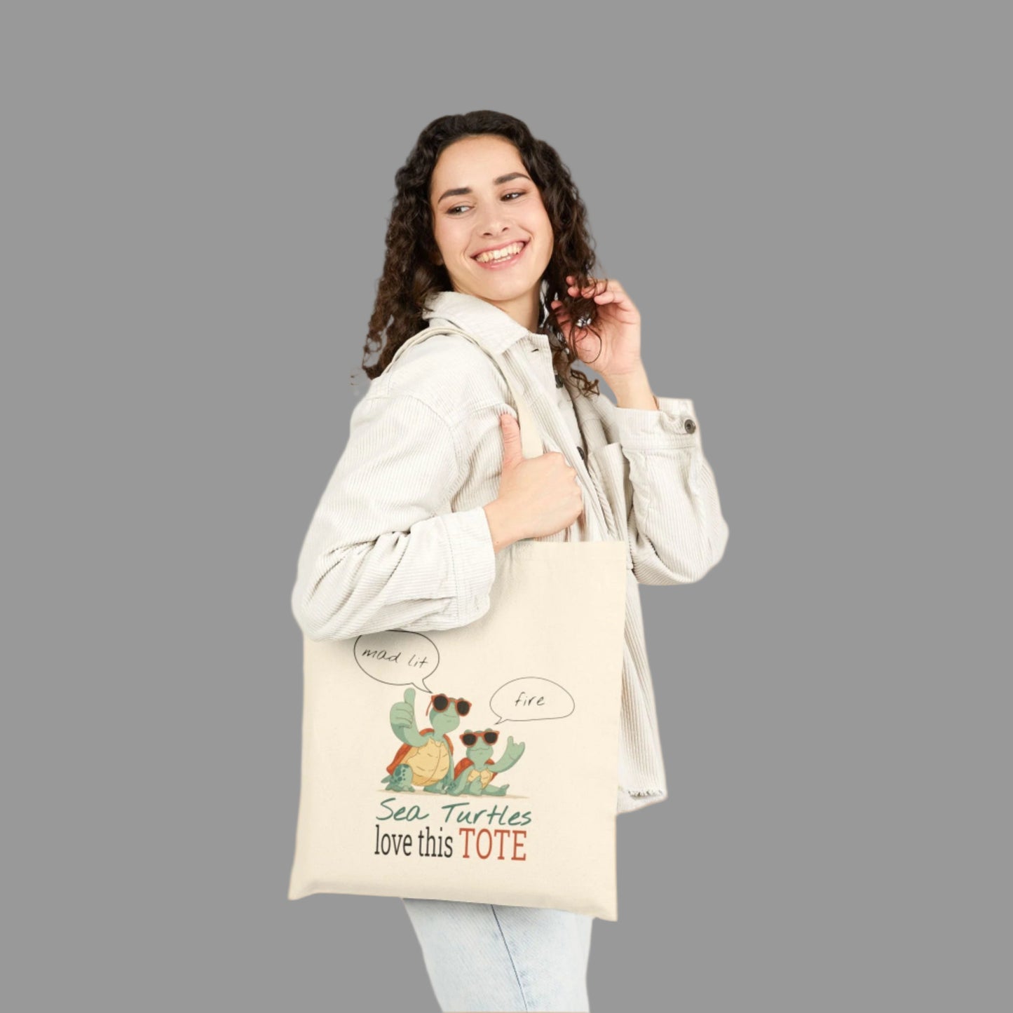 Woman holding a tote bag with sea turtle design and text