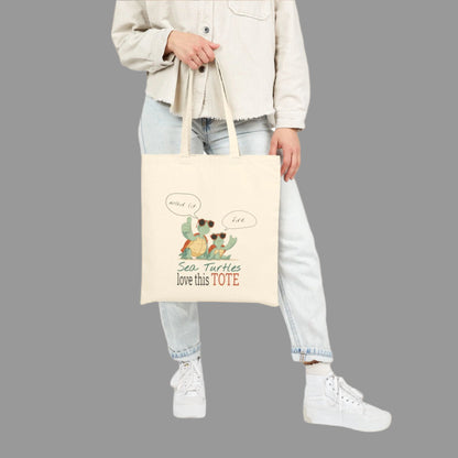 Person holding a tote bag with sea turtle design and text on a white background