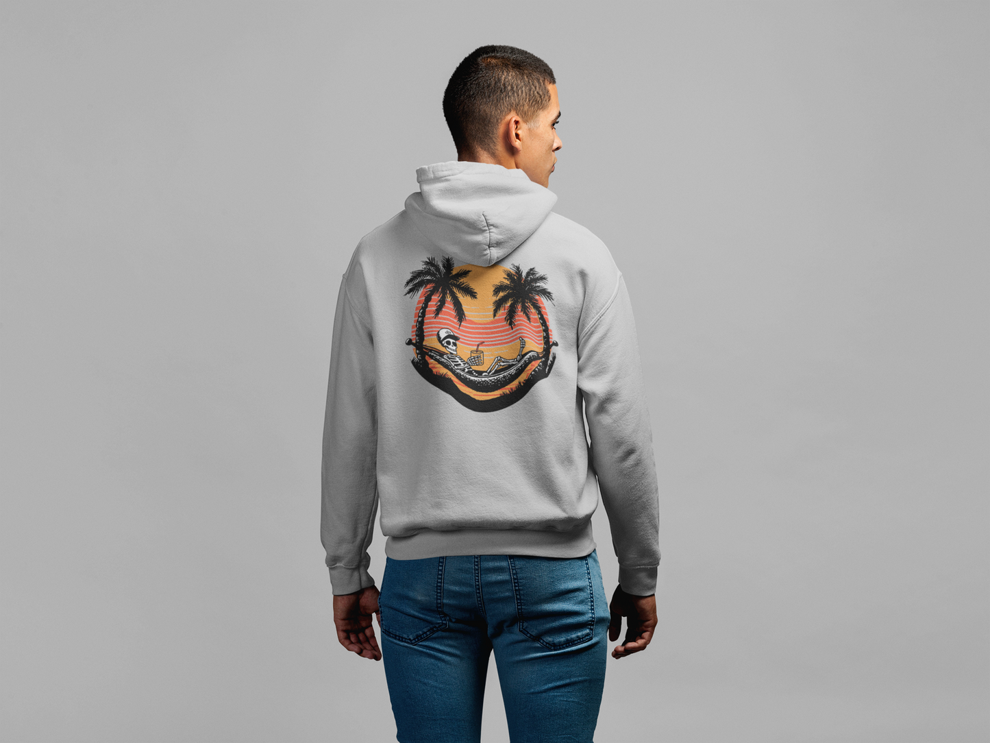 Person wearing a gray hoodie with a palm tree design on the back against a gray background