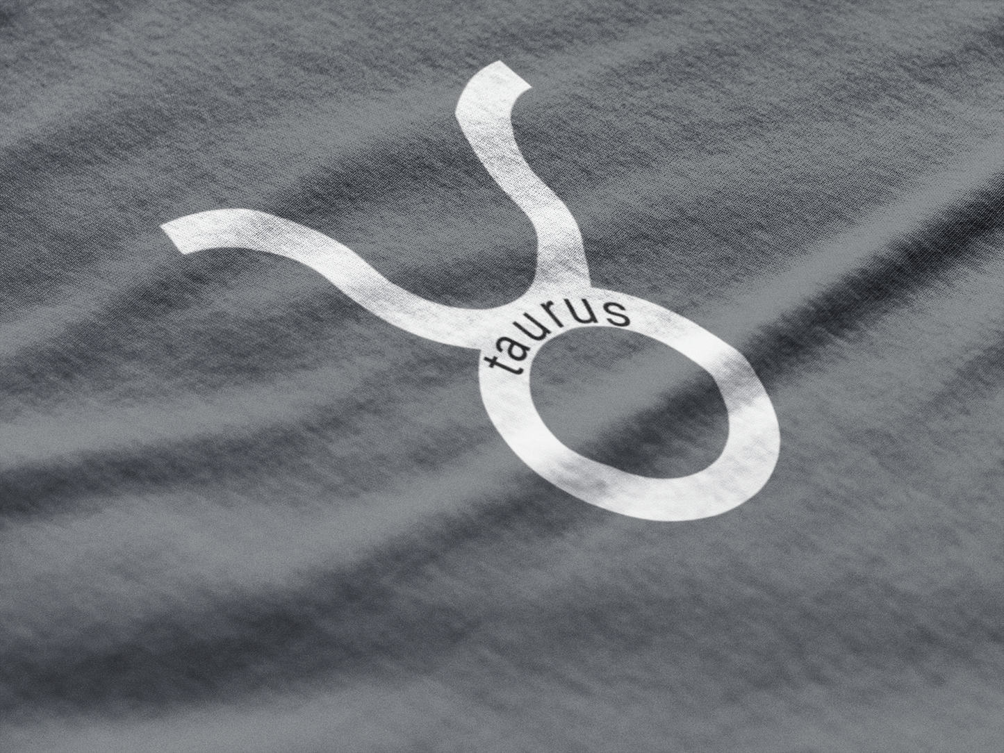 Taurus zodiac symbol on a gray fabric background
