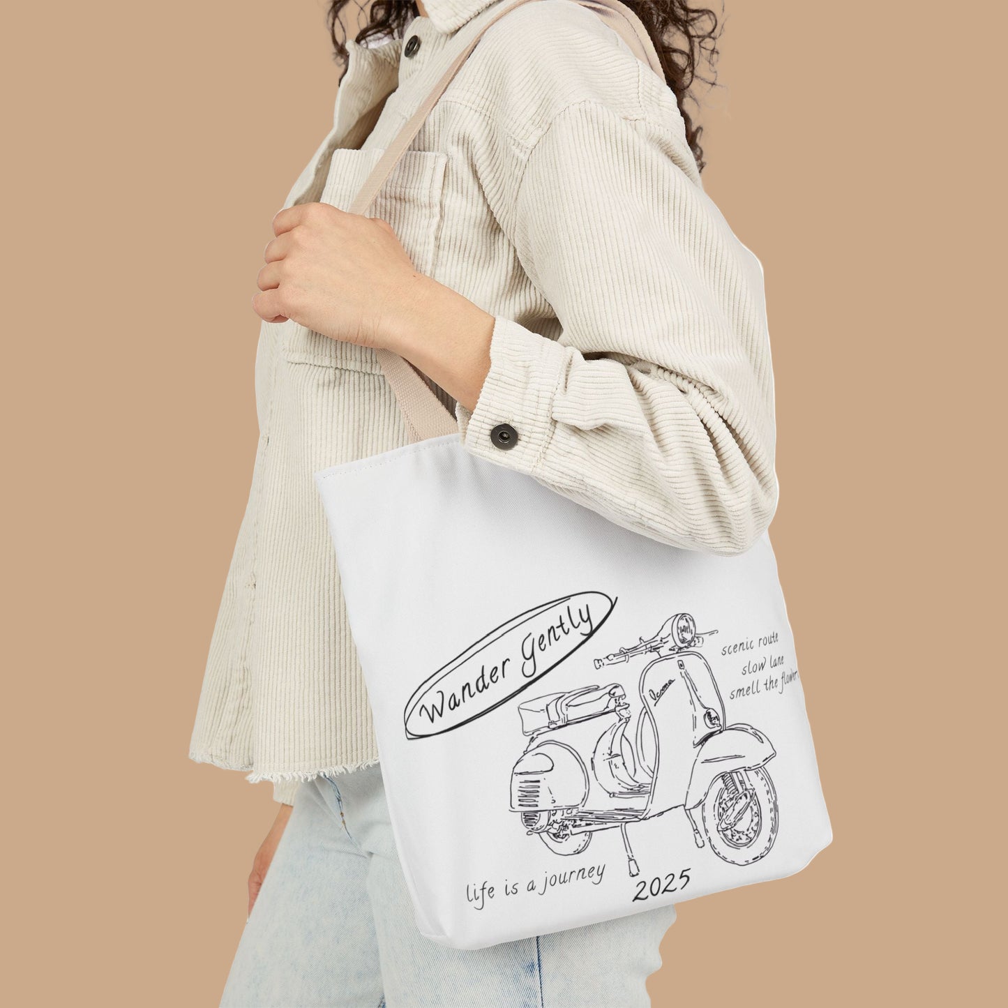 Person holding a tote bag with a scooter design and text.
