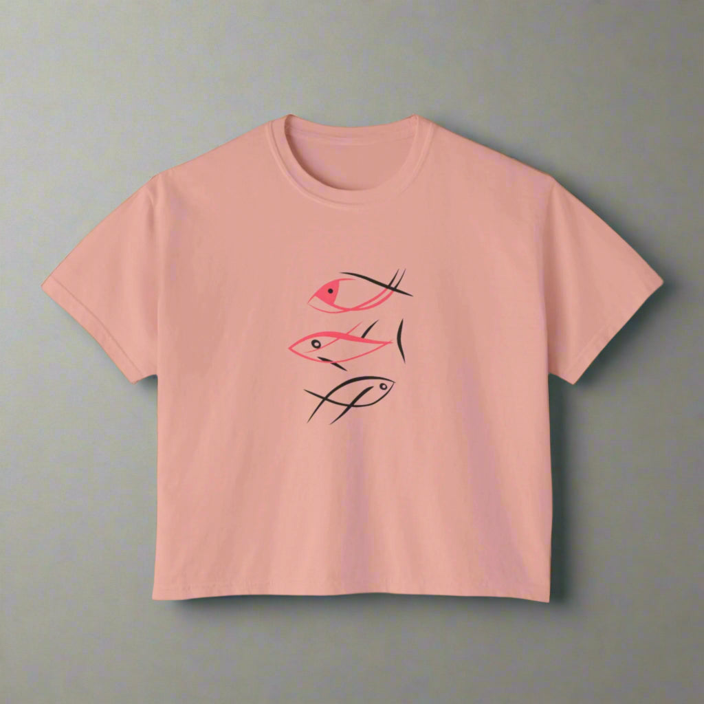 Pink t-shirt with black and red fish illustrations on a white background