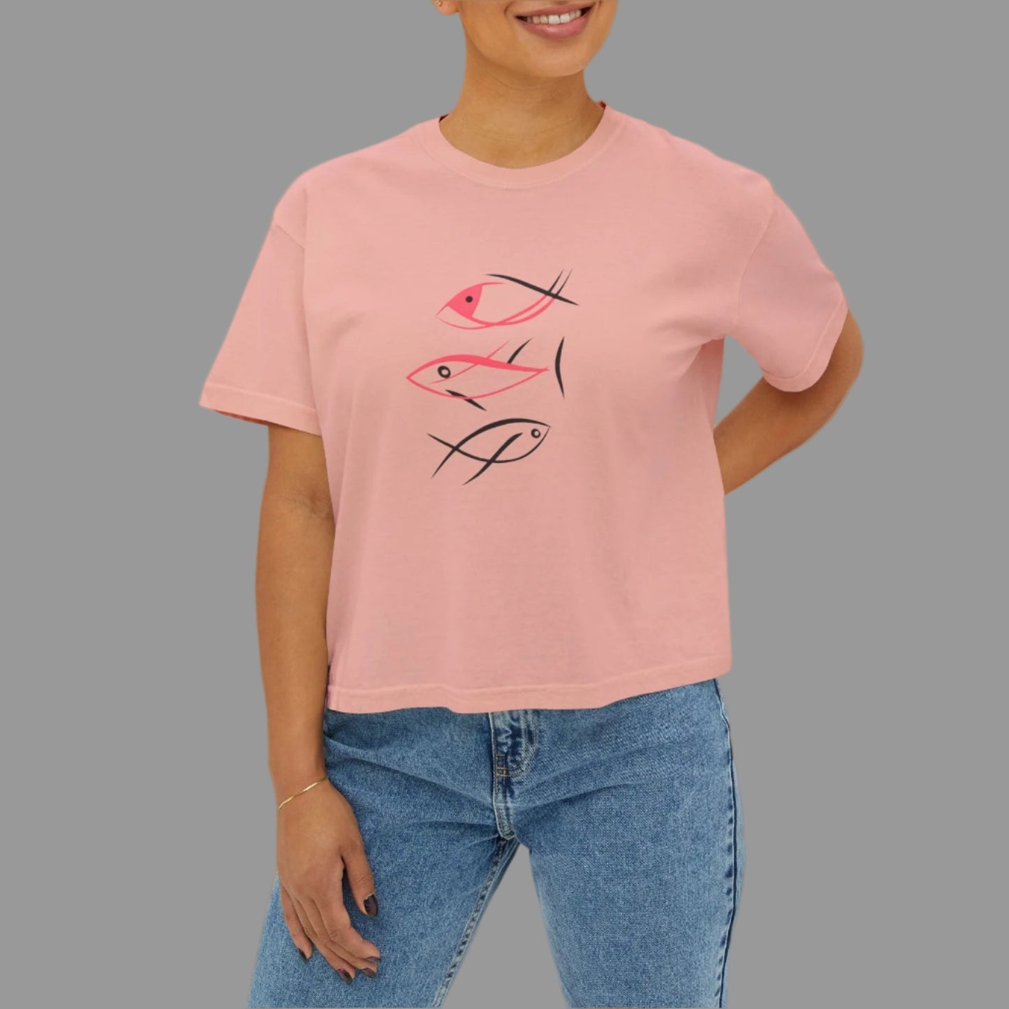 Person wearing a pink t-shirt with a graphic design on a white background