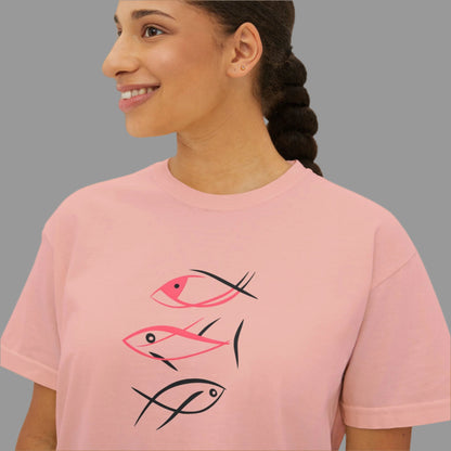Woman wearing a pink t-shirt with fish designs on a white background