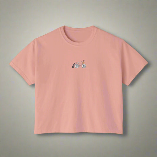 Pink t-shirt with a small bicycle graphic on a white background