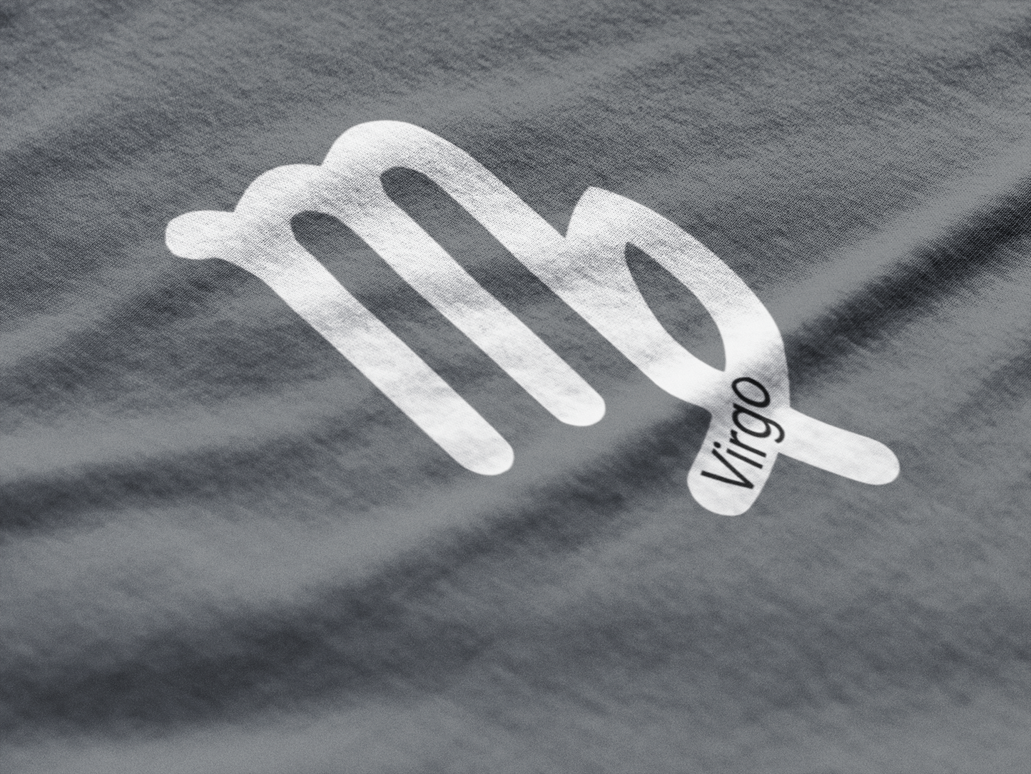 Silver Virgo zodiac sign on a gray fabric background