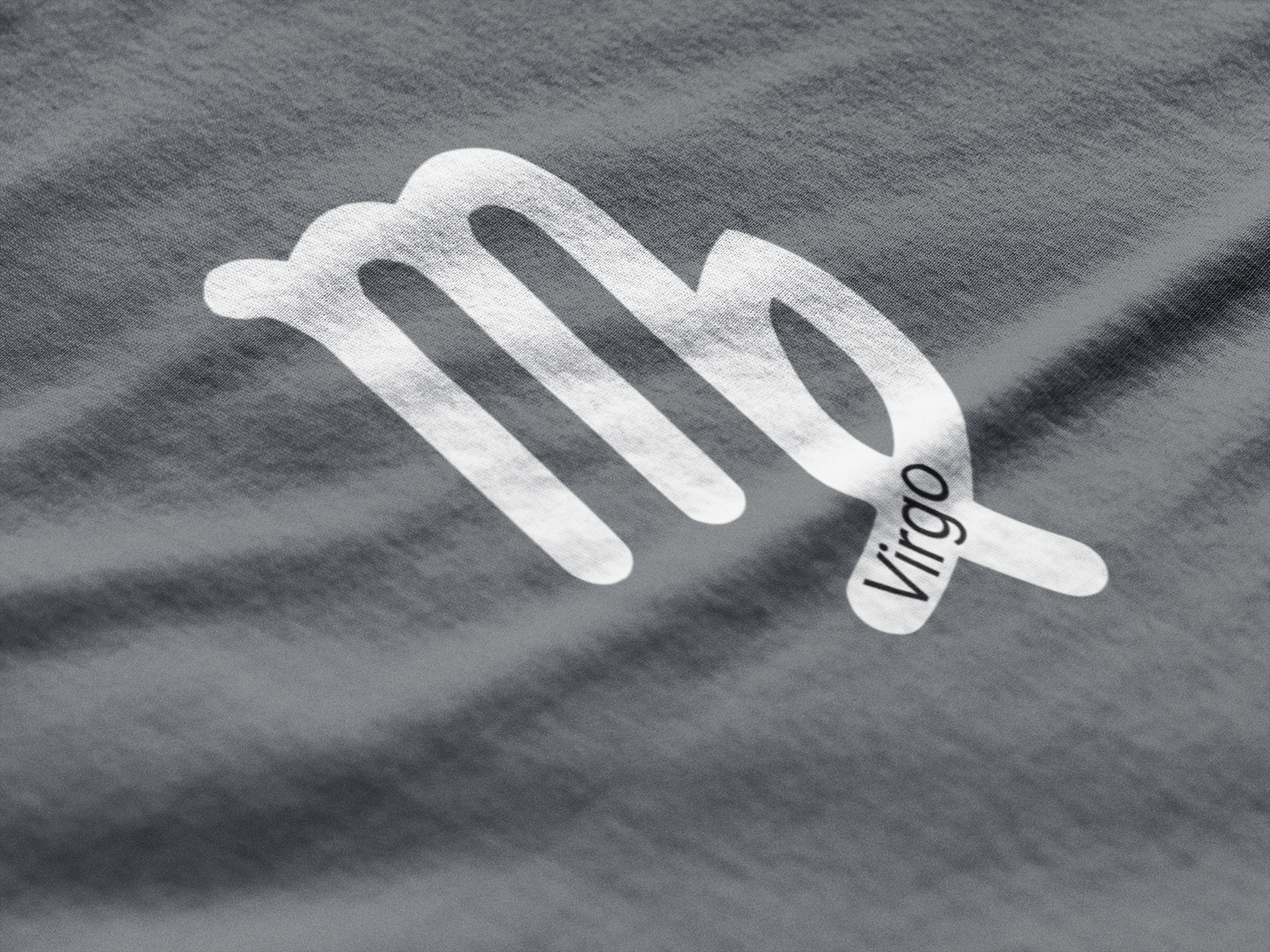 Silver Virgo zodiac sign on a gray fabric background