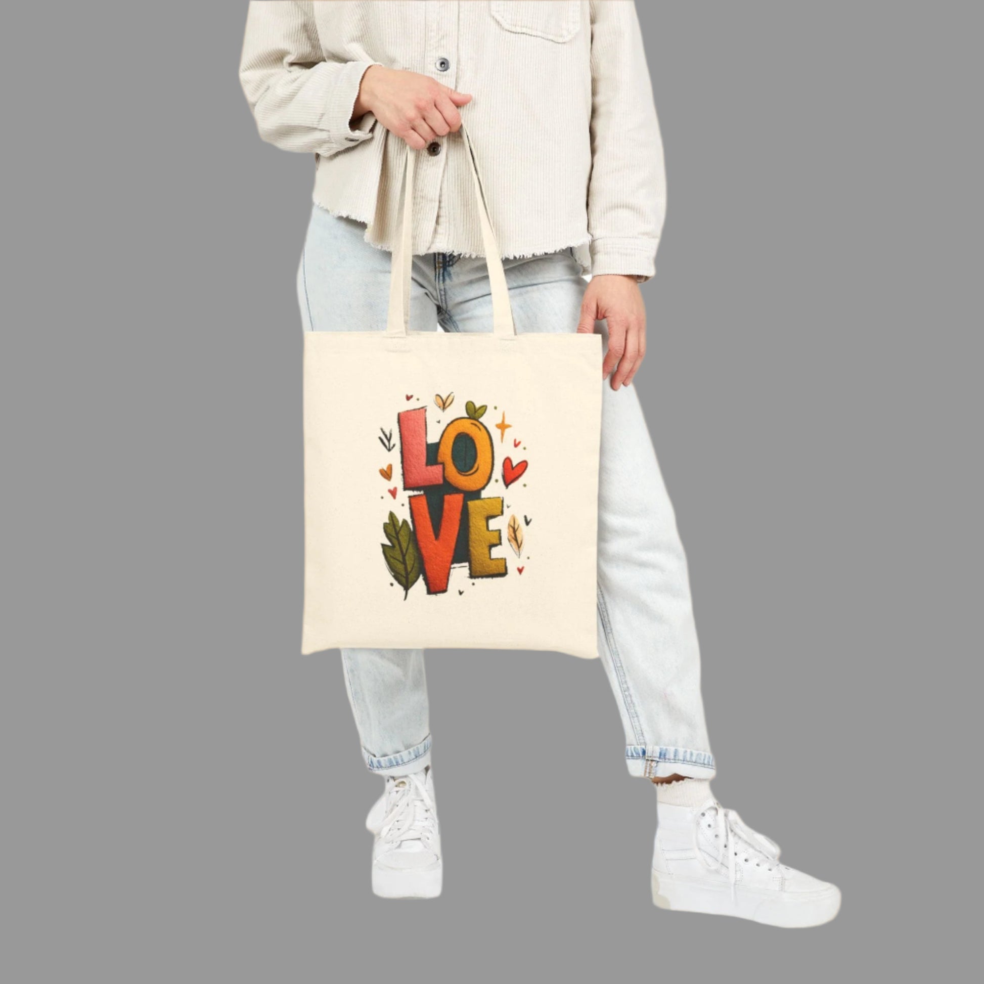 Person holding a tote bag with 'LOVE' printed on it against a white background