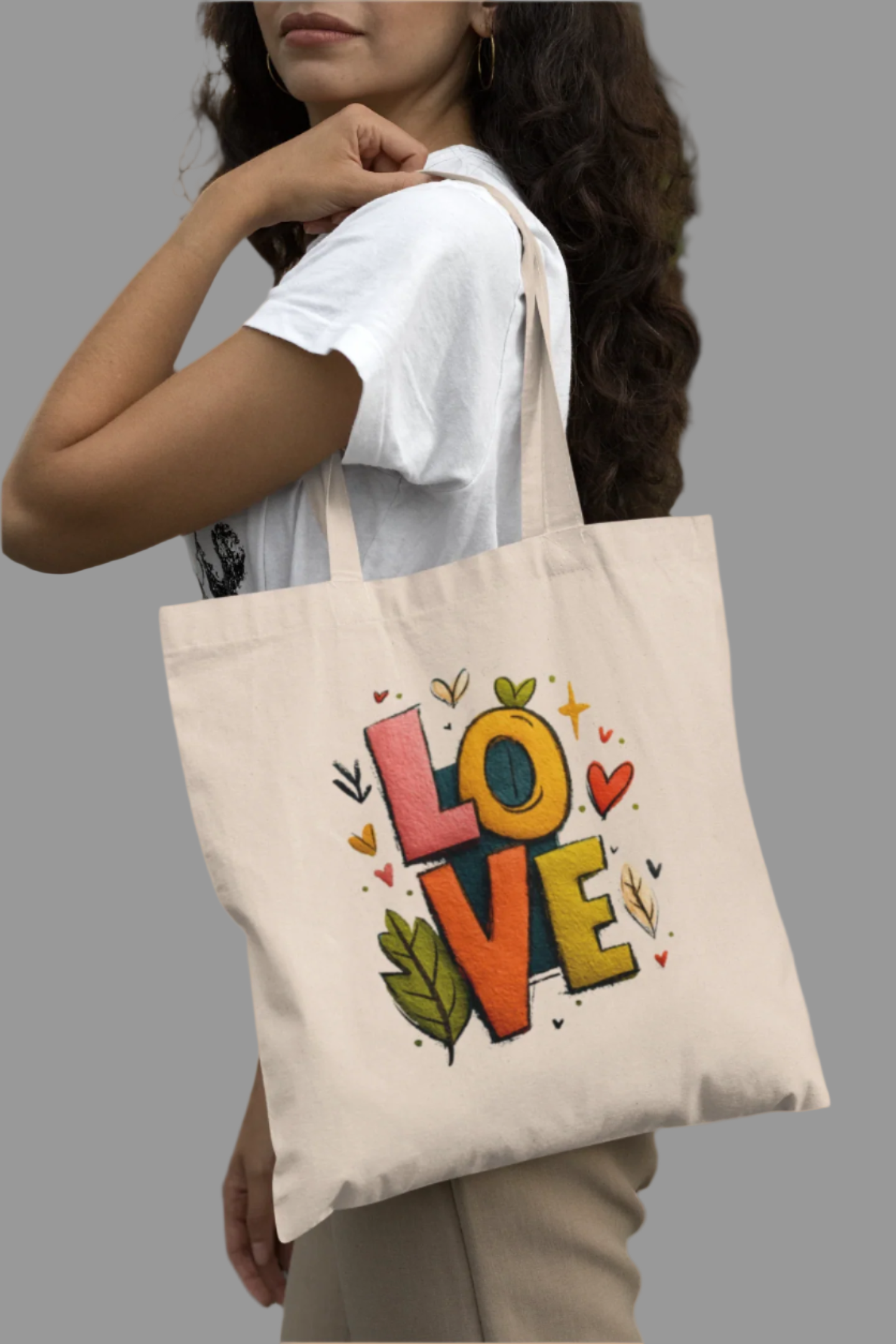 Woman holding a tote bag with 'LOVE' design outdoors