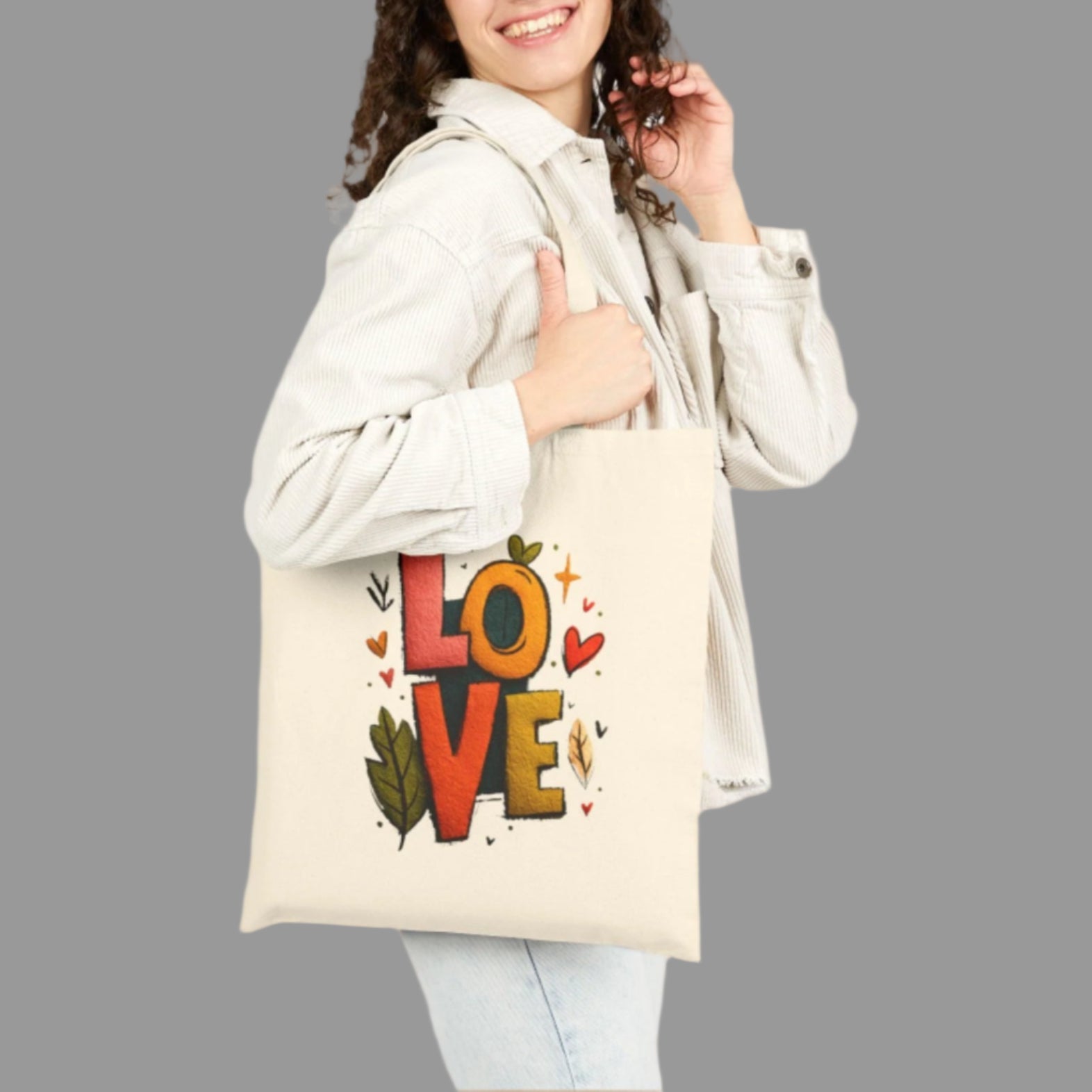 Woman holding a tote bag with 'LOVE' design on a white background