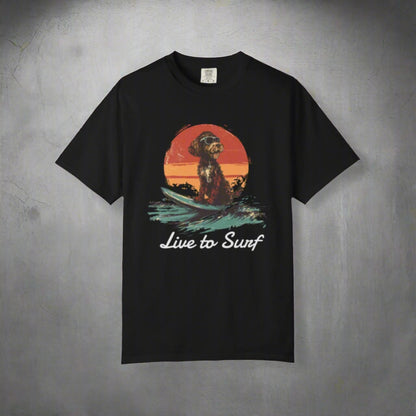 Black t-shirt with a dog on a surfboard graphic and 'Live to Surf' text on a white background