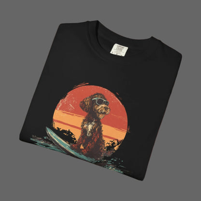 Black t-shirt with a graphic of a dog on a surfboard and sunset design.
