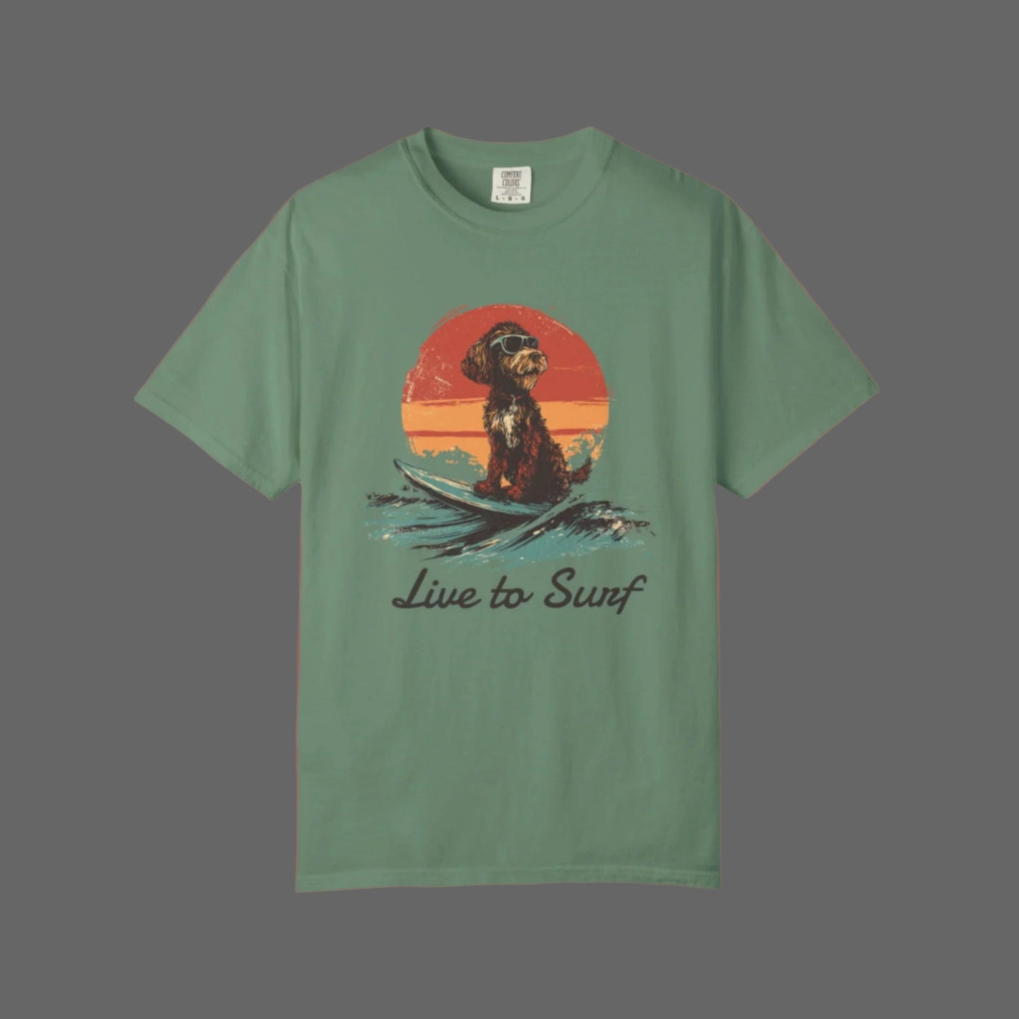 Green t-shirt with a dog surfing graphic and 'Live to Surf' text on a white background