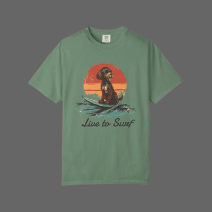 Green t-shirt with a dog surfing graphic and 'Live to Surf' text on a white background
