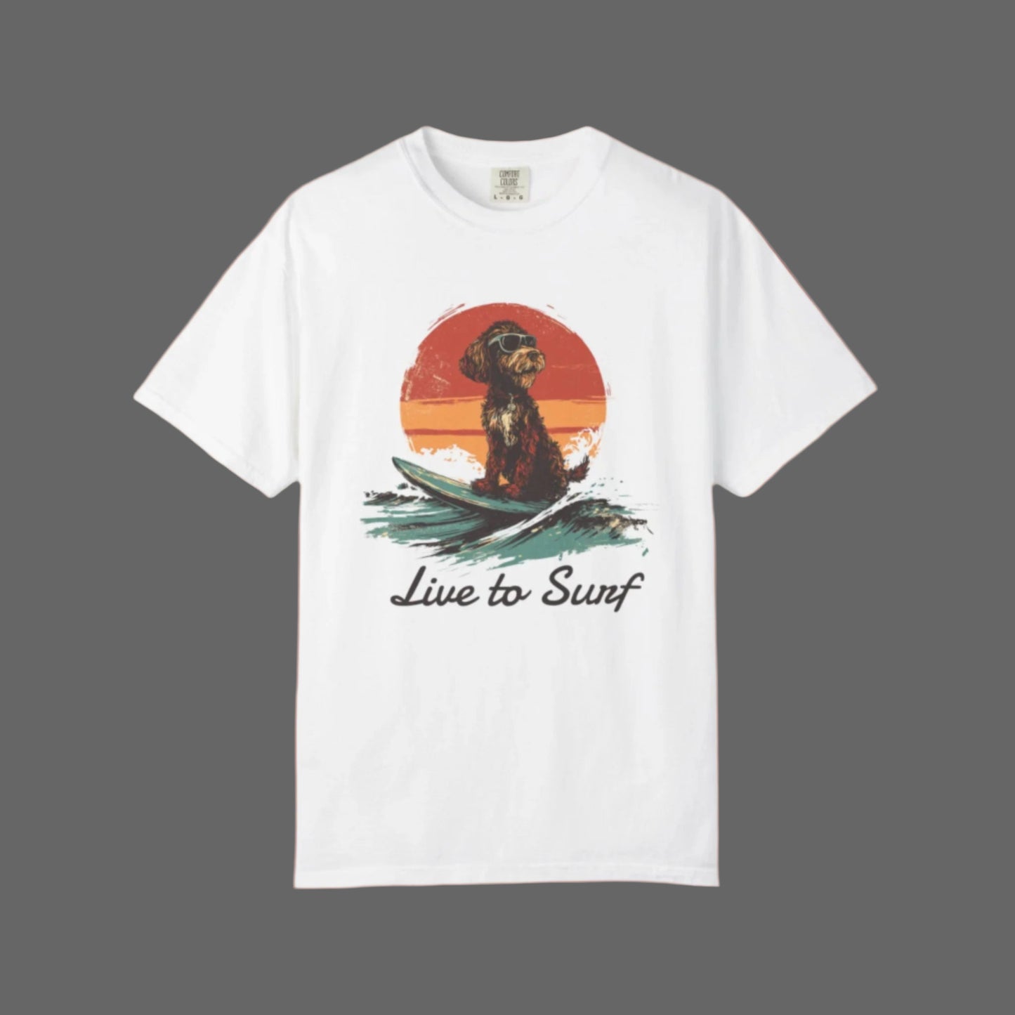 White t-shirt with a graphic of a dog on a surfboard and 'Live to Surf' text, on a white background.