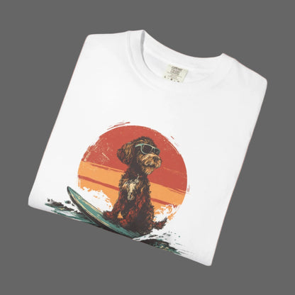 White t-shirt with a graphic of a dog on a surfboard and sunset design.