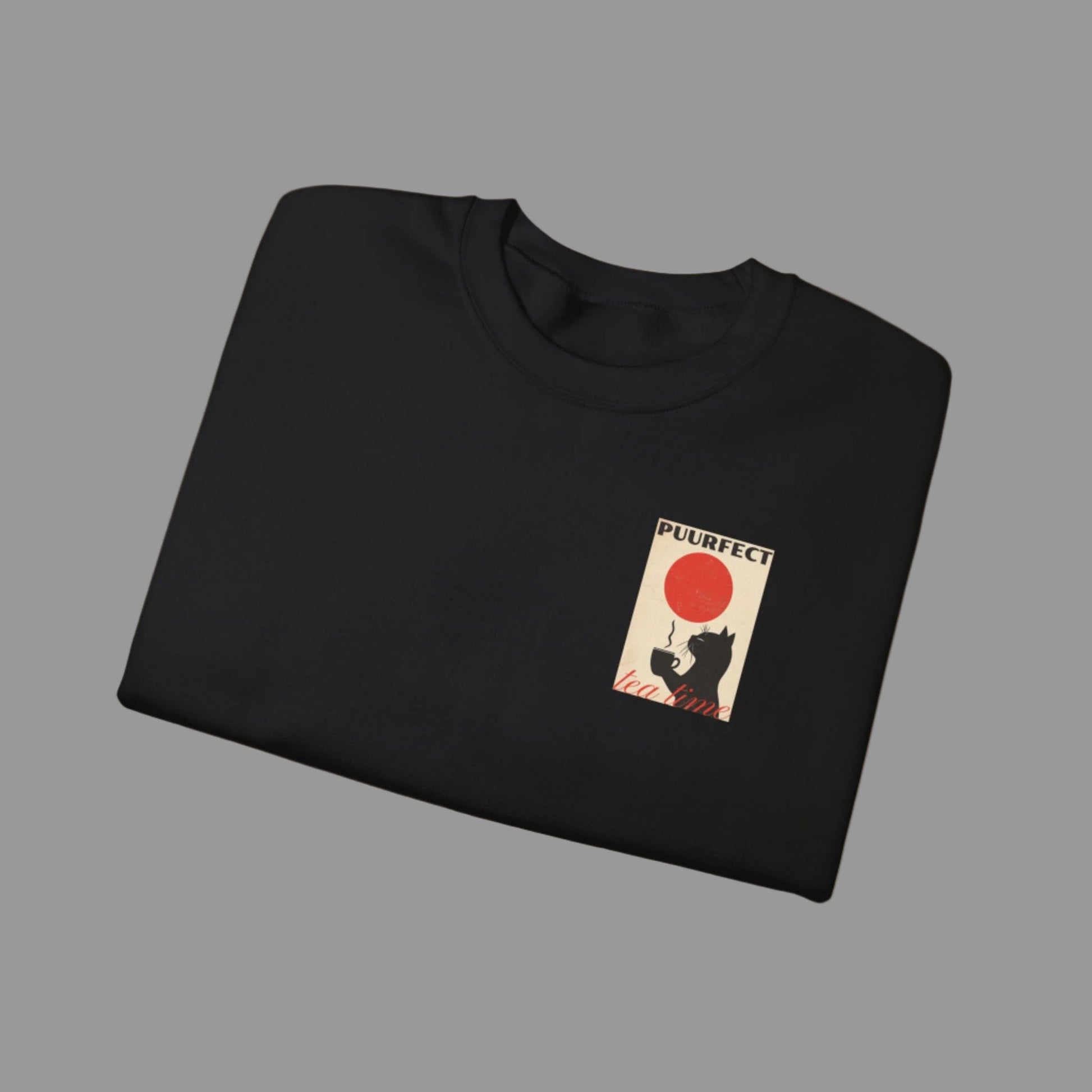 Folded black sweatshirt with a graphic of a cat and red balloon on a white background