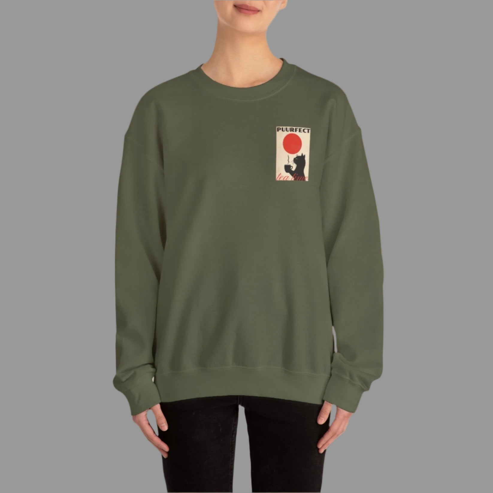 Person wearing a green sweatshirt with a graphic design on a white background