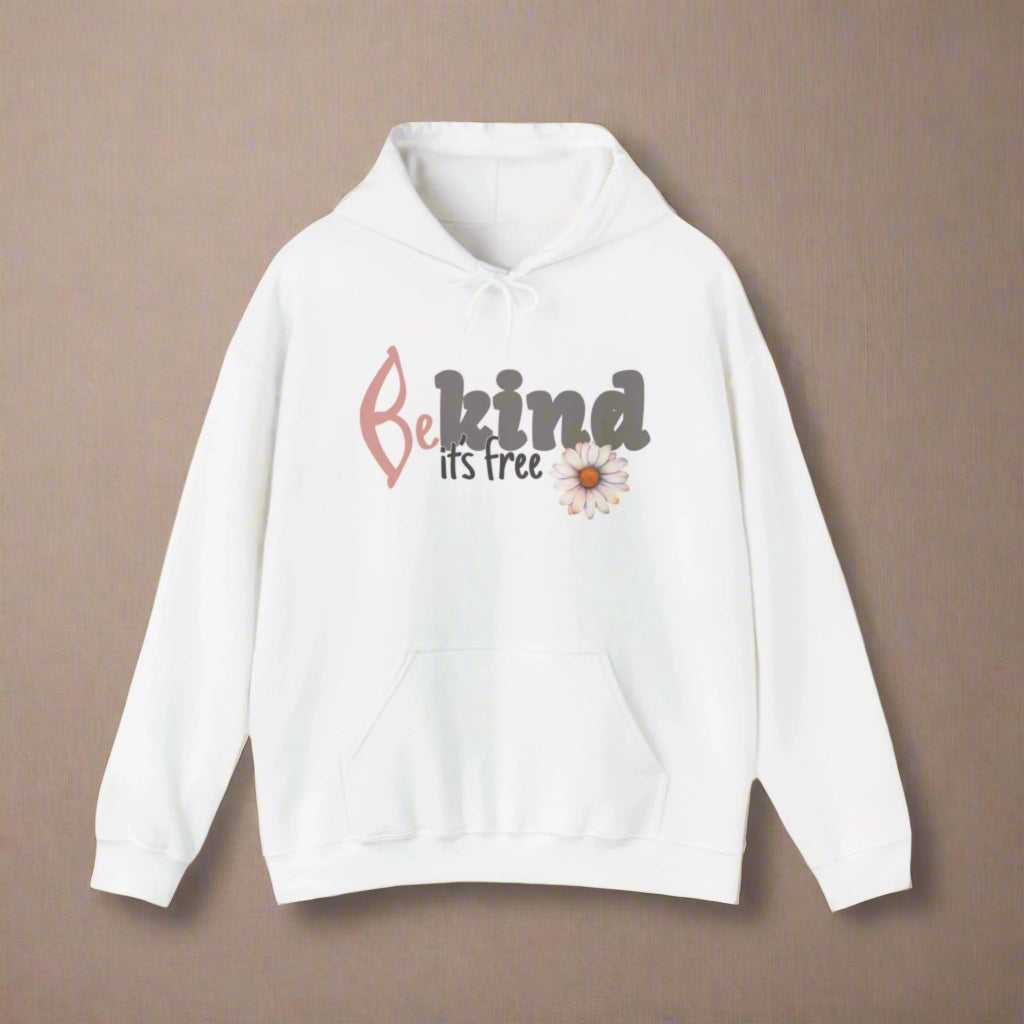 A woman smiling, wearing a white hoodie with the text 'BE KIND IT'S FREE' and a floral design on the front.