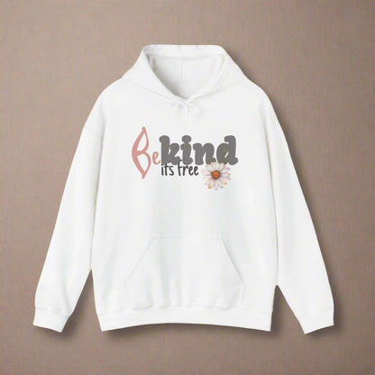 A woman smiling, wearing a white hoodie with the text 'BE KIND IT'S FREE' and a floral design on the front.