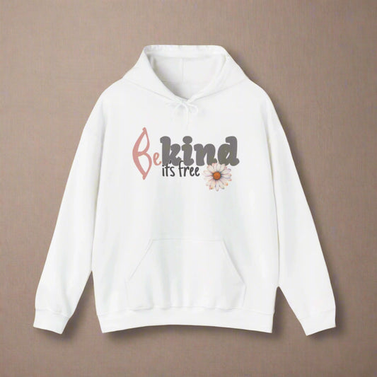 A woman smiling, wearing a white hoodie with the text 'BE KIND IT'S FREE' and a floral design on the front.